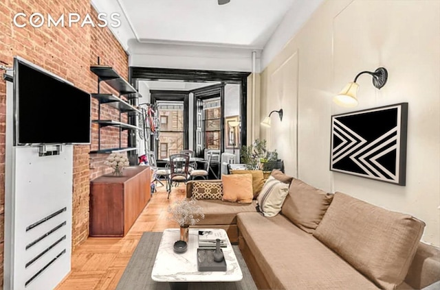 living room featuring light parquet flooring and brick wall