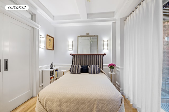 2 W 67th St Unit 3G, New York City, NY 10023 - bedroom featuring wainscoting, coffered ceiling, light wood finished floors, and beam ceiling
