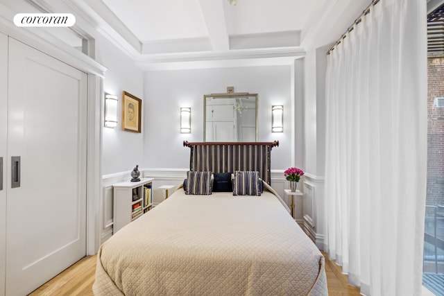 bedroom with beamed ceiling, coffered ceiling, and light hardwood / wood-style flooring