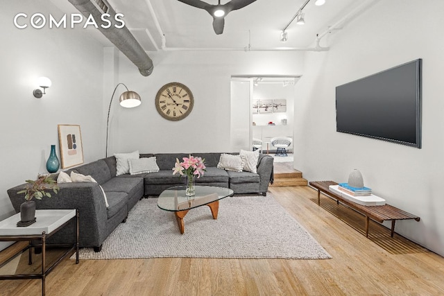 living room with rail lighting and light hardwood / wood-style flooring