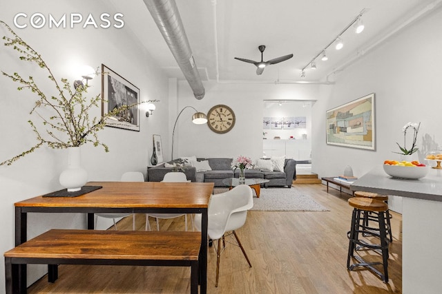 dining space with a ceiling fan, light wood-style flooring, and track lighting