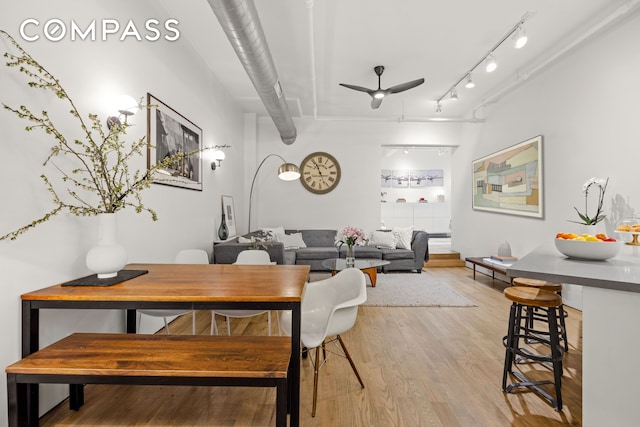 dining area featuring ceiling fan, light wood finished floors, and rail lighting