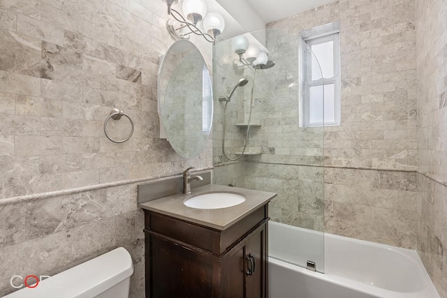 full bathroom with vanity, tiled shower / bath combo, and toilet