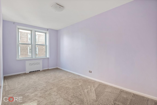 carpeted empty room with radiator heating unit