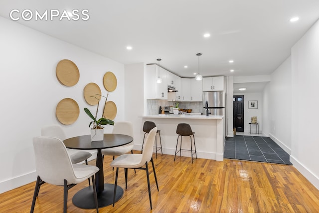 dining area featuring recessed lighting, baseboards, and wood finished floors