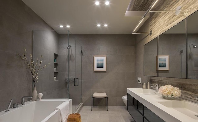 full bathroom featuring plus walk in shower, tile walls, tile patterned flooring, vanity, and toilet