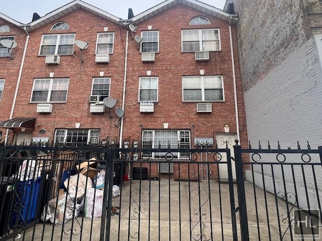 multi unit property featuring brick siding and a fenced front yard