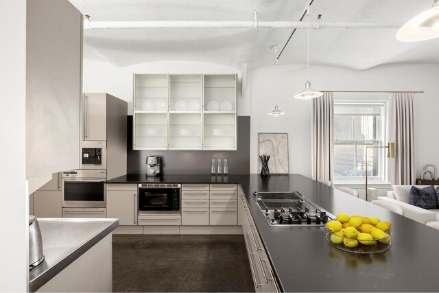 kitchen with stainless steel appliances, white cabinets, and decorative light fixtures