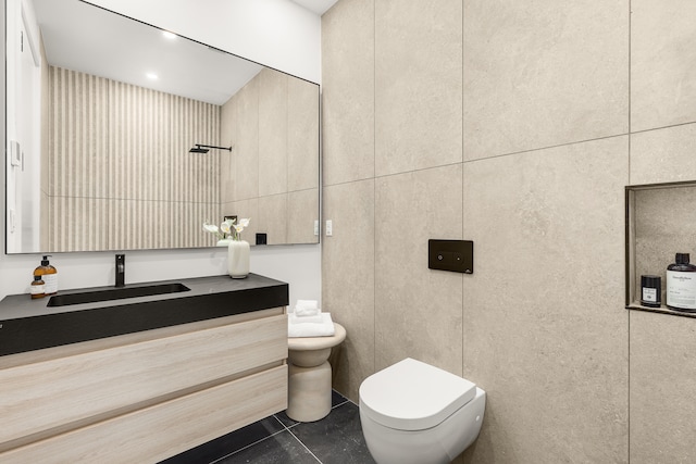 bathroom with toilet, tile walls, tile patterned flooring, and vanity