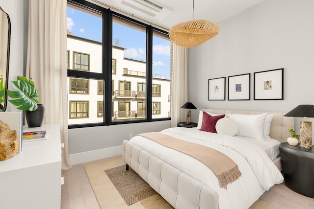 bedroom featuring baseboards and wood finished floors