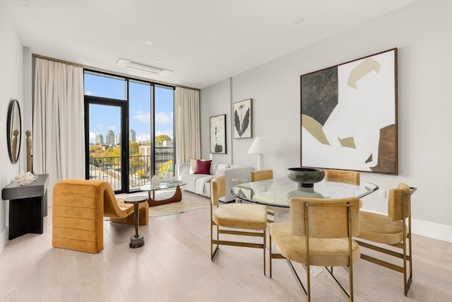 dining space featuring expansive windows and light hardwood / wood-style floors