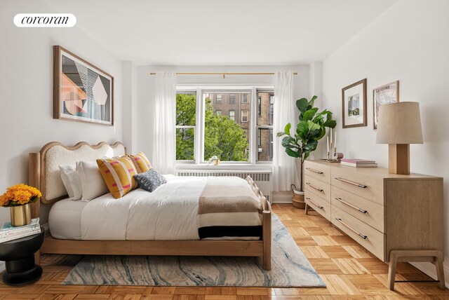 bedroom featuring light parquet flooring and radiator heating unit