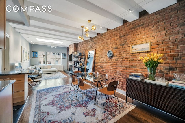 dining room with dark wood-type flooring, beamed ceiling, and brick wall