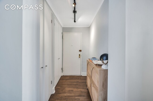 corridor featuring track lighting and dark hardwood / wood-style flooring