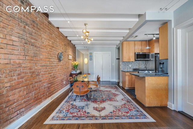 kitchen with decorative backsplash, stainless steel appliances, dark hardwood / wood-style flooring, and hanging light fixtures