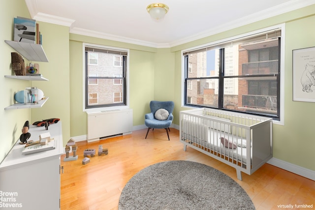 bedroom with hardwood / wood-style floors, crown molding, and radiator