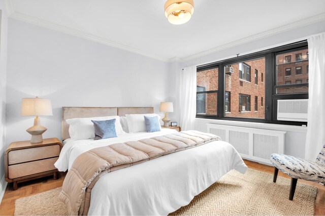 bedroom with radiator, crown molding, and light hardwood / wood-style floors