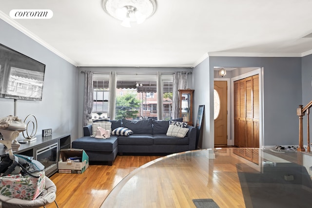 living area with stairs, crown molding, wood finished floors, and visible vents