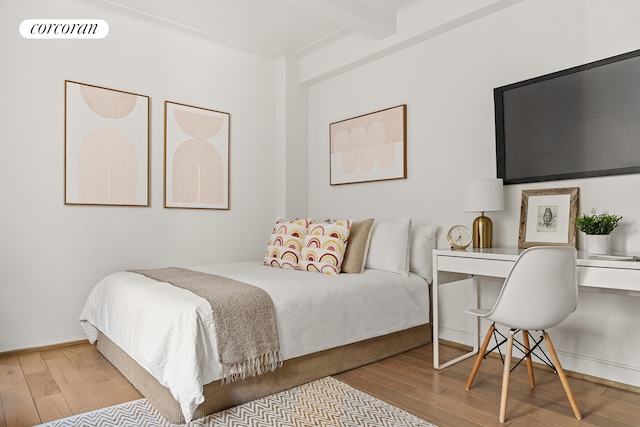 bedroom featuring beam ceiling, visible vents, and wood finished floors