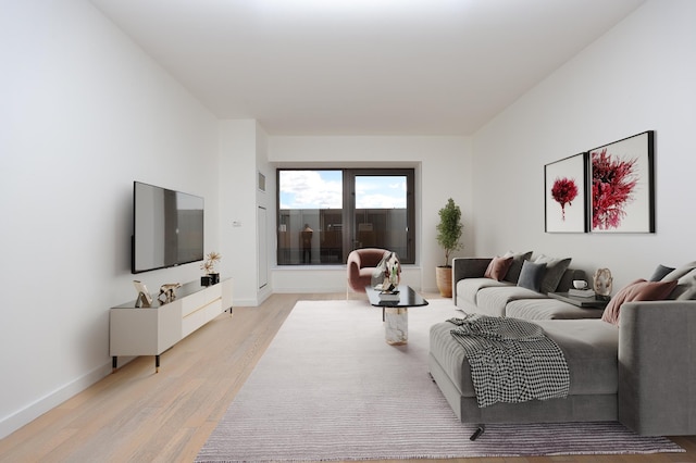 living area featuring visible vents, light wood-style floors, and baseboards