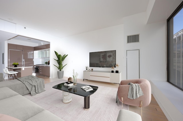 living area featuring visible vents and light wood-style floors