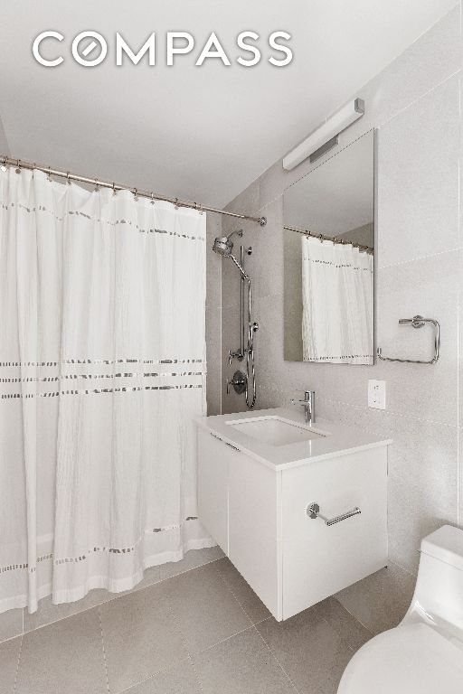 bathroom featuring vanity, tile patterned flooring, a shower with curtain, and toilet