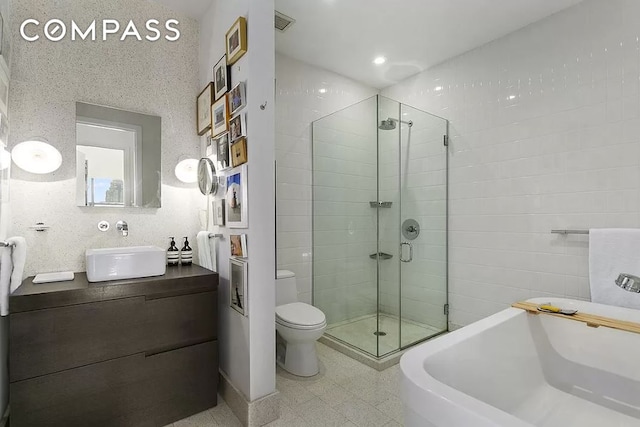 full bath featuring toilet, visible vents, vanity, a soaking tub, and a shower stall