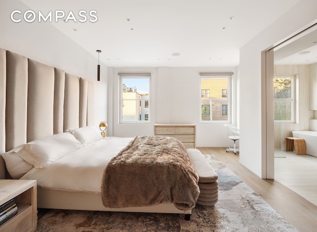 bedroom featuring multiple windows and wood finished floors