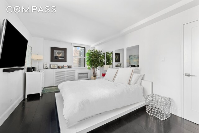 bedroom with dark hardwood / wood-style flooring