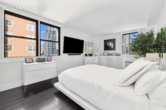 bedroom featuring multiple windows and dark hardwood / wood-style floors