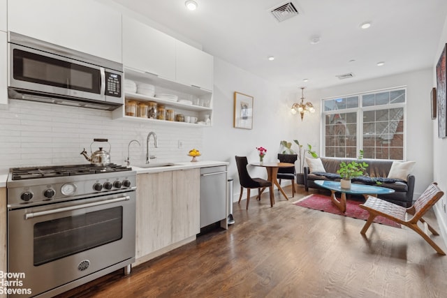 kitchen featuring sink, decorative light fixtures, dark hardwood / wood-style flooring, stainless steel appliances, and decorative backsplash