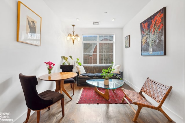 living area featuring an inviting chandelier and wood-type flooring