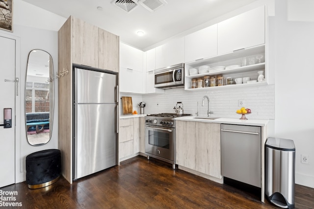 kitchen featuring stainless steel appliances, tasteful backsplash, sink, and dark hardwood / wood-style flooring