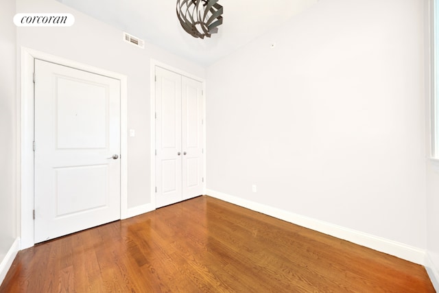 unfurnished bedroom featuring hardwood / wood-style flooring and a closet