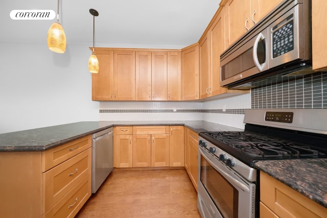 kitchen with dark stone countertops, light brown cabinetry, decorative light fixtures, and appliances with stainless steel finishes