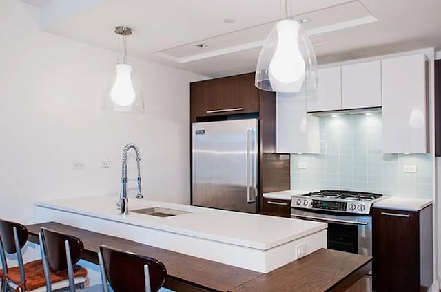 2-17 51st Ave Unit 902, New York City, NY 11101 - kitchen with stainless steel appliances, a sink, dark brown cabinetry, light countertops, and decorative backsplash