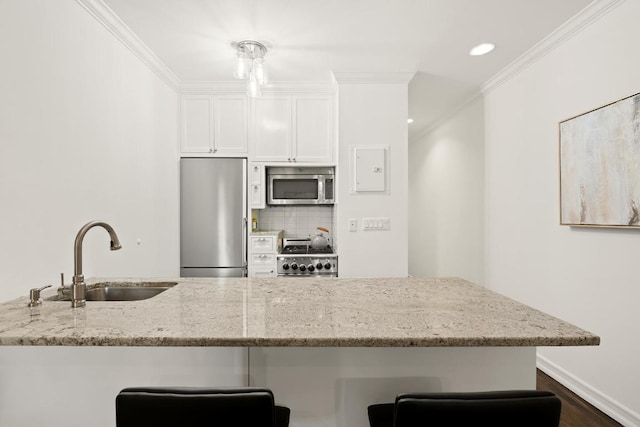 kitchen with sink, white cabinetry, crown molding, light stone counters, and stainless steel appliances