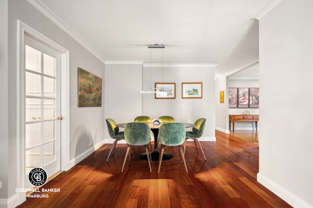 dining room with baseboards, crown molding, and wood finished floors