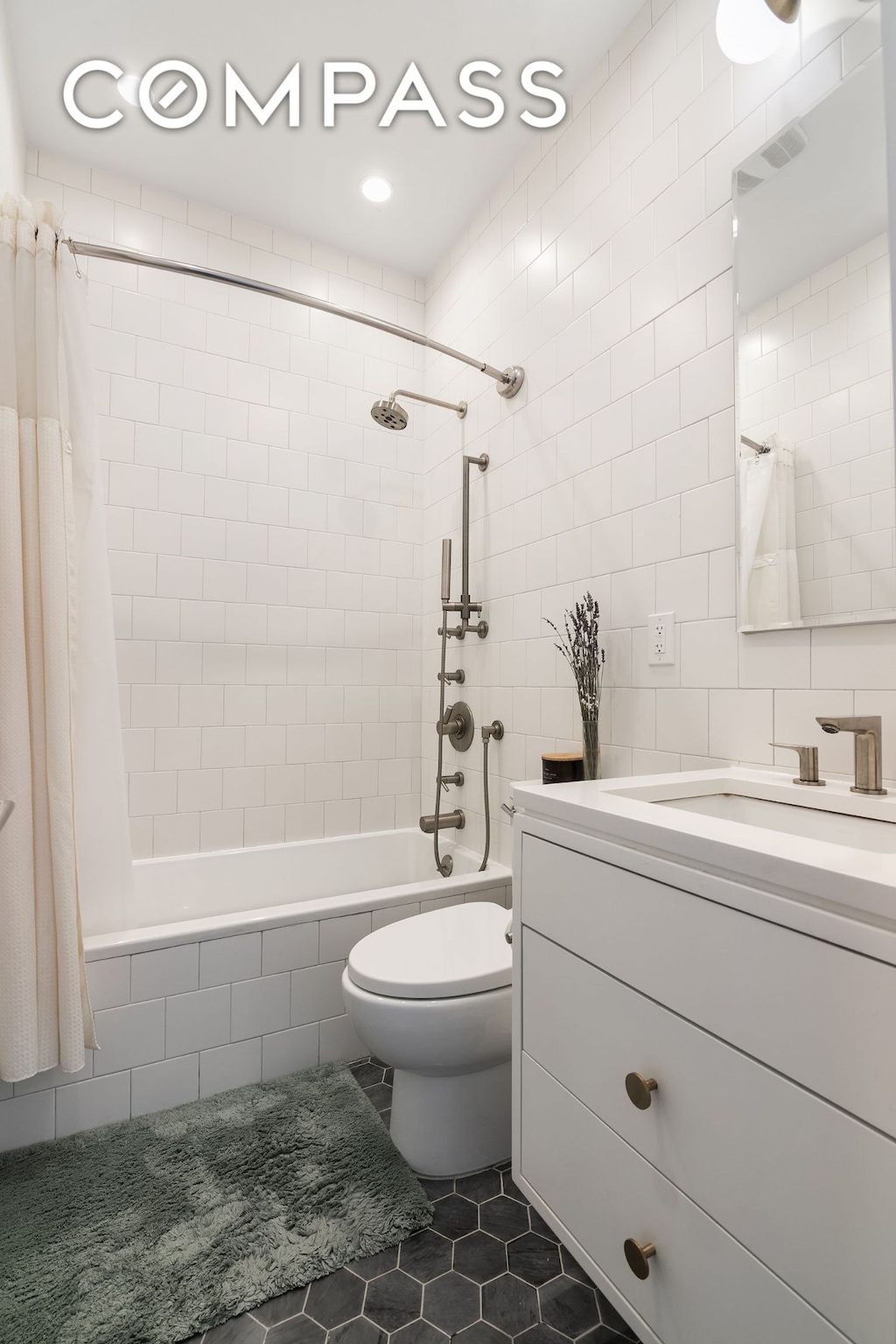 bathroom with tile patterned flooring, visible vents, toilet, tiled shower / bath combo, and tile walls