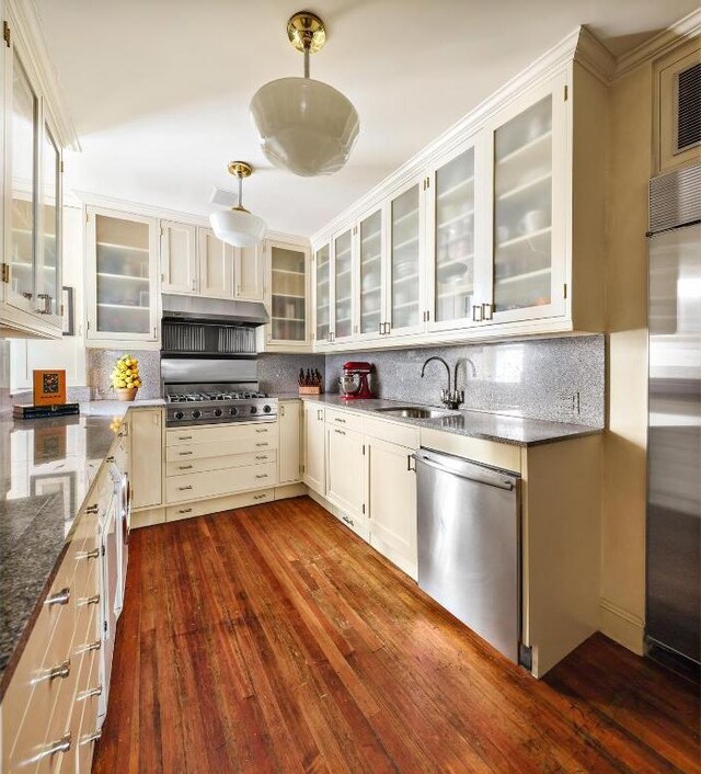 kitchen featuring sink, decorative light fixtures, appliances with stainless steel finishes, dark hardwood / wood-style floors, and decorative backsplash