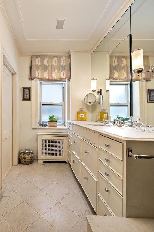 bathroom featuring tile patterned floors, ornamental molding, radiator, and vanity