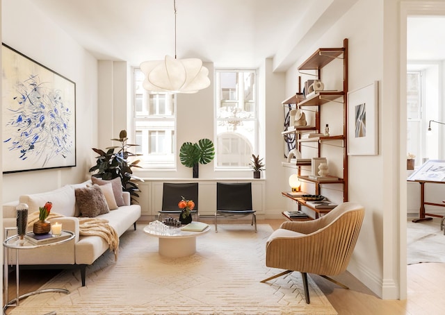 living area with baseboards, wood finished floors, and a healthy amount of sunlight