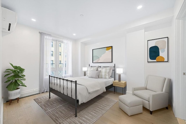 bedroom with light wood finished floors, a wall mounted AC, and recessed lighting