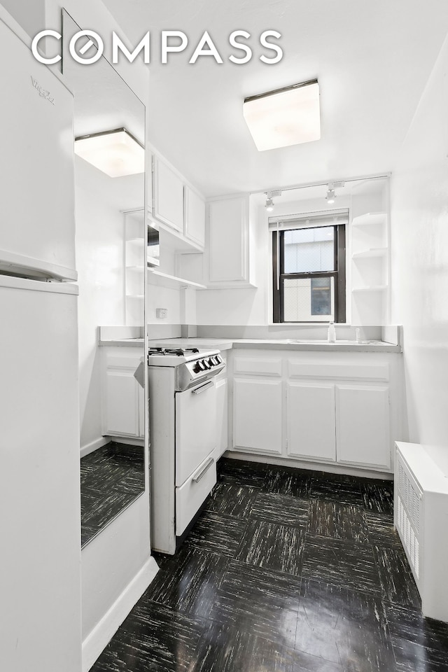 kitchen featuring white cabinets, white appliances, and light countertops
