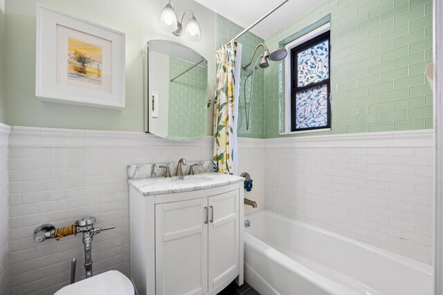 full bathroom featuring wainscoting, toilet, shower / bath combination with curtain, vanity, and tile walls