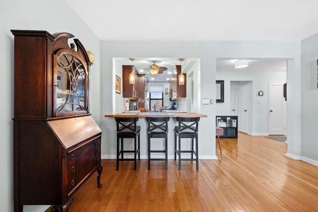 kitchen featuring light hardwood / wood-style floors, a kitchen breakfast bar, and kitchen peninsula