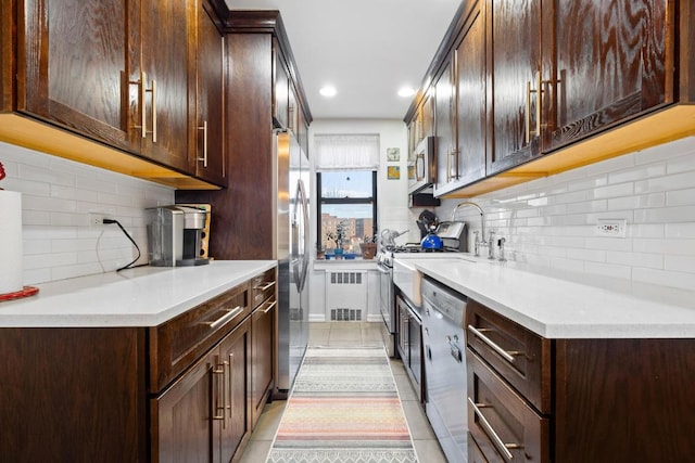 kitchen featuring stainless steel appliances, light countertops, dark brown cabinets, and light tile patterned floors