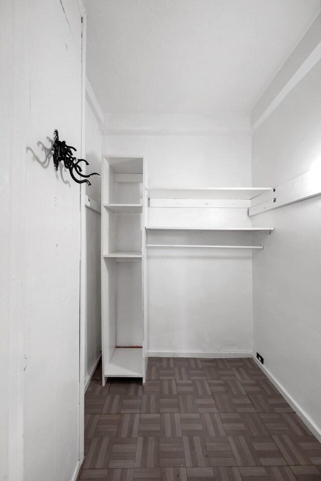 walk in closet featuring dark parquet floors