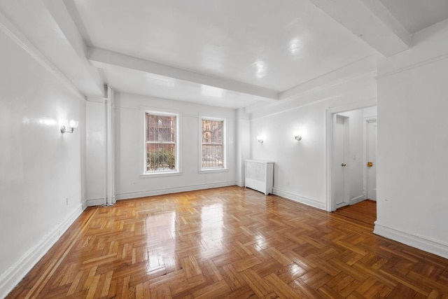 spare room featuring beamed ceiling and baseboards