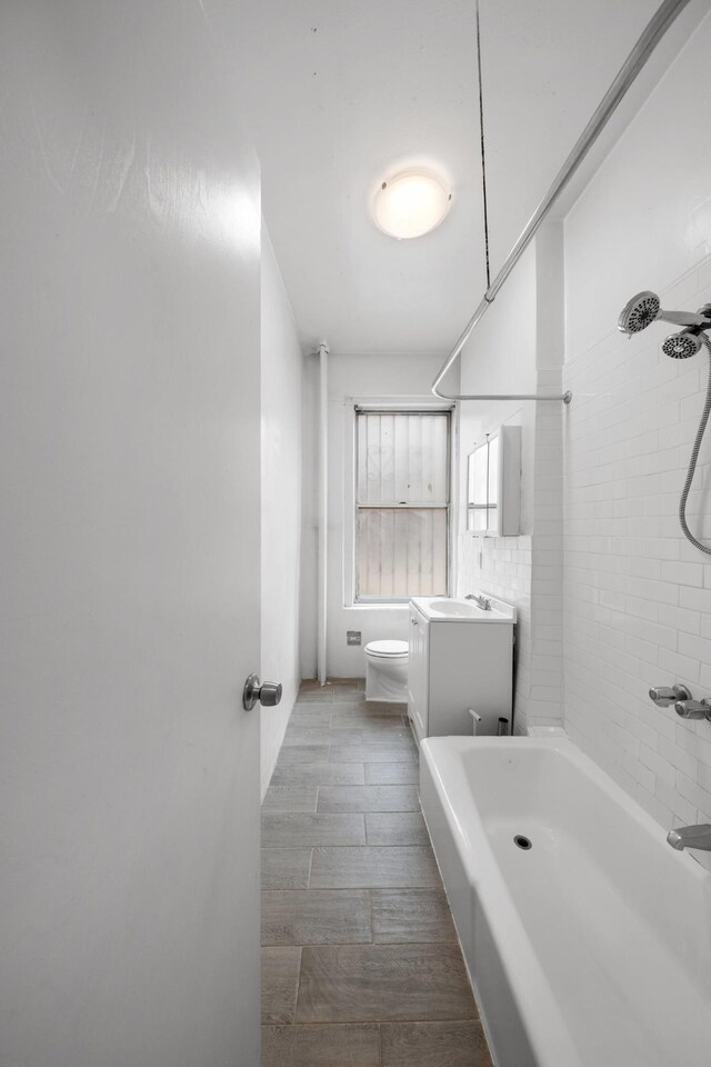 full bathroom featuring vanity, toilet, and tiled shower / bath combo